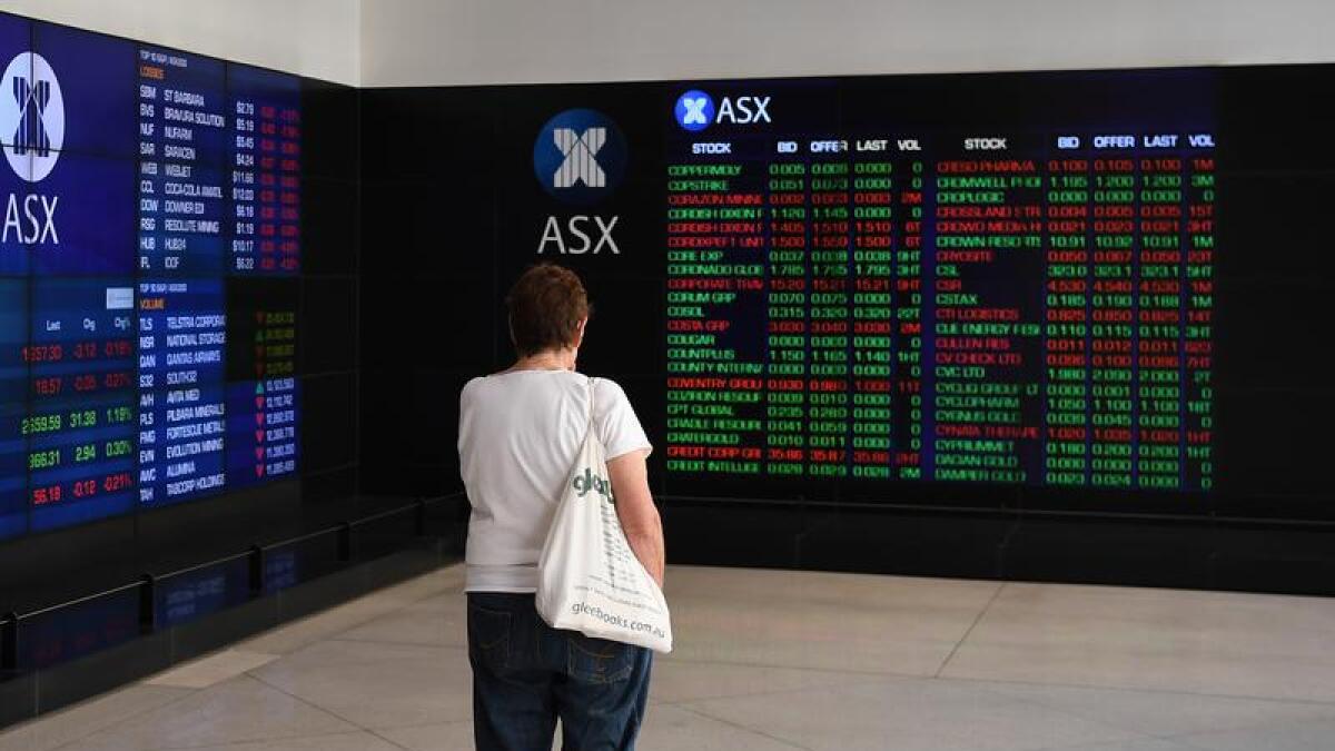 A woman looks at an ASX trading display.