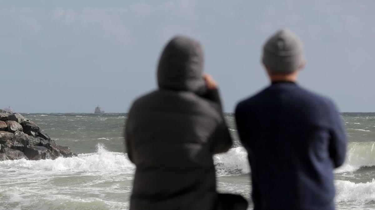 People look out to sea from Cottesloe Beach.