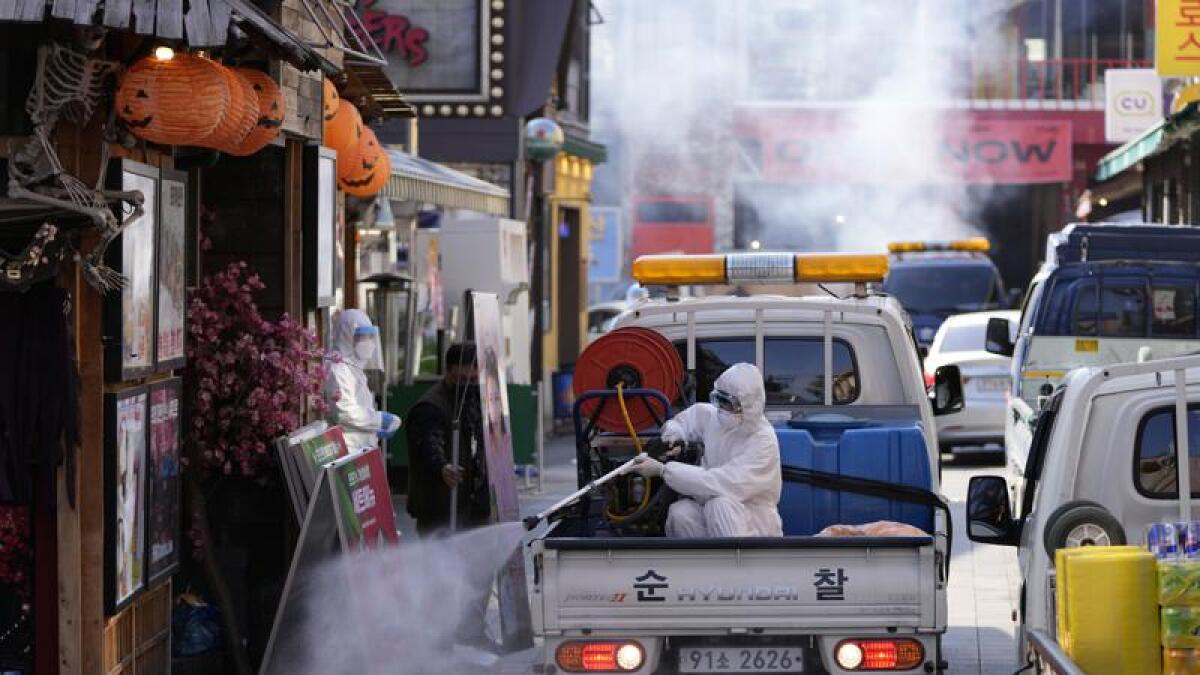 Health official disinfects shop fronts in Seoul