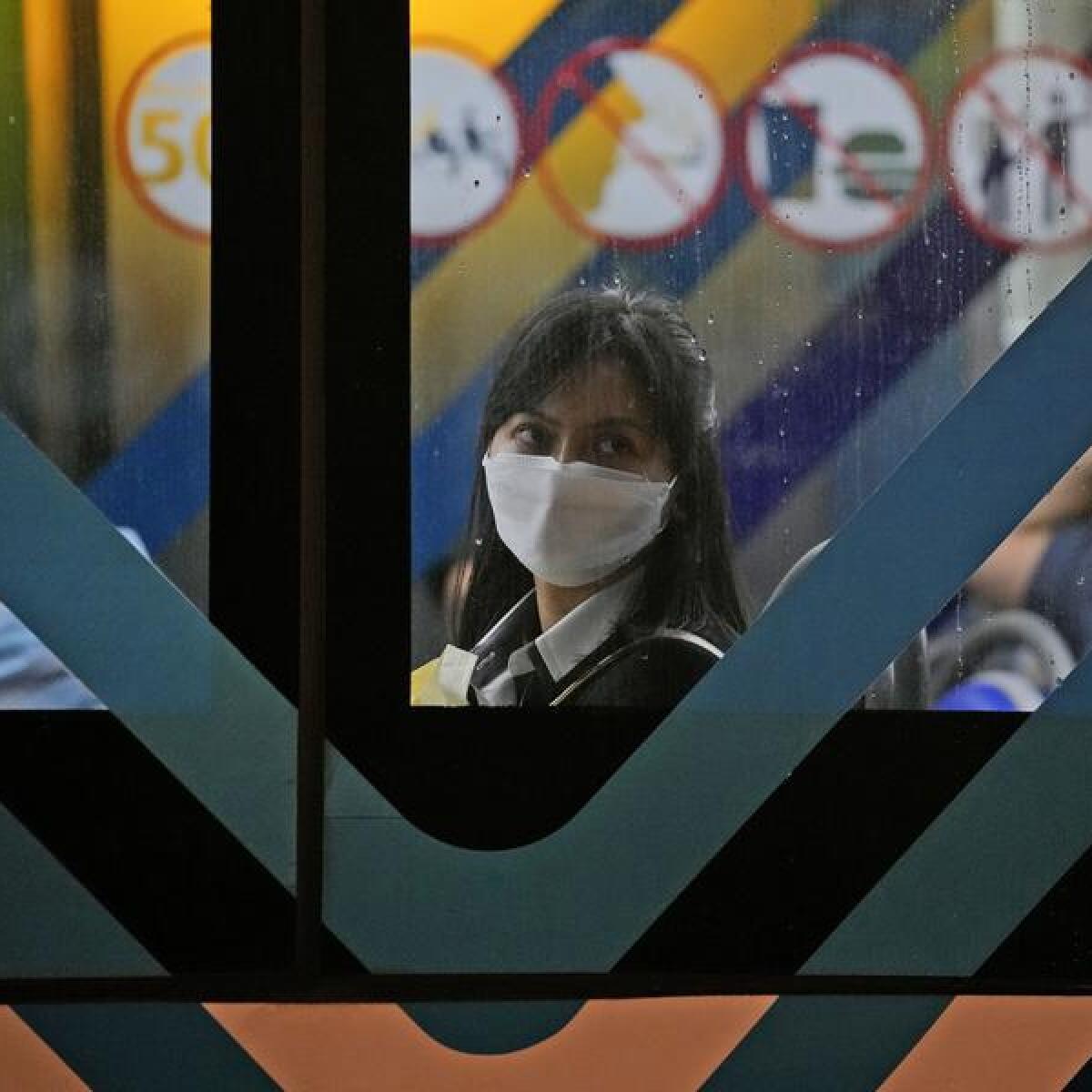 A woman wears a mask on a bus in Jakarta