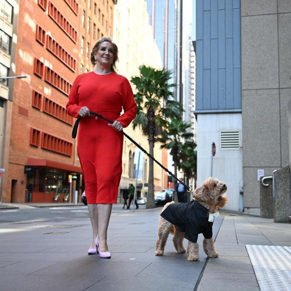 Gina Edwards, with her Cavoodle Oscar, arrives at the Federal Court