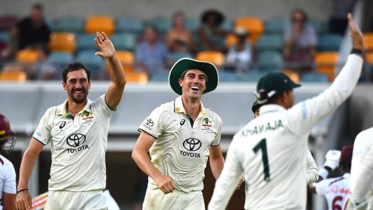 Pat Cummins and fellow Australian players celebrate a wicket.
