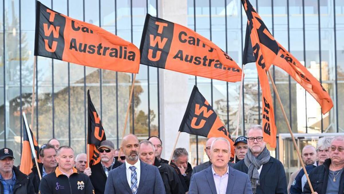 Michael Kaine, surrounded by sacked Qantas workers