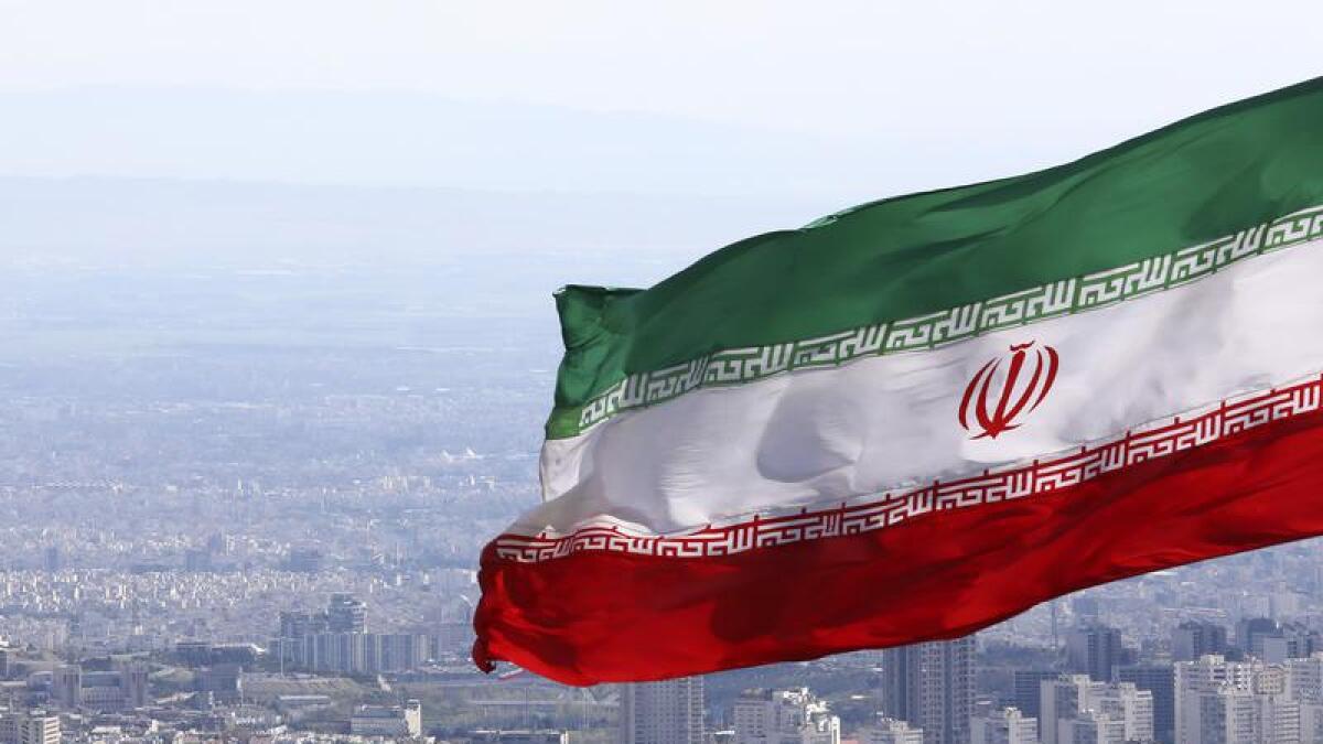 Iranian flag above Milad telecommunications tower in Tehran