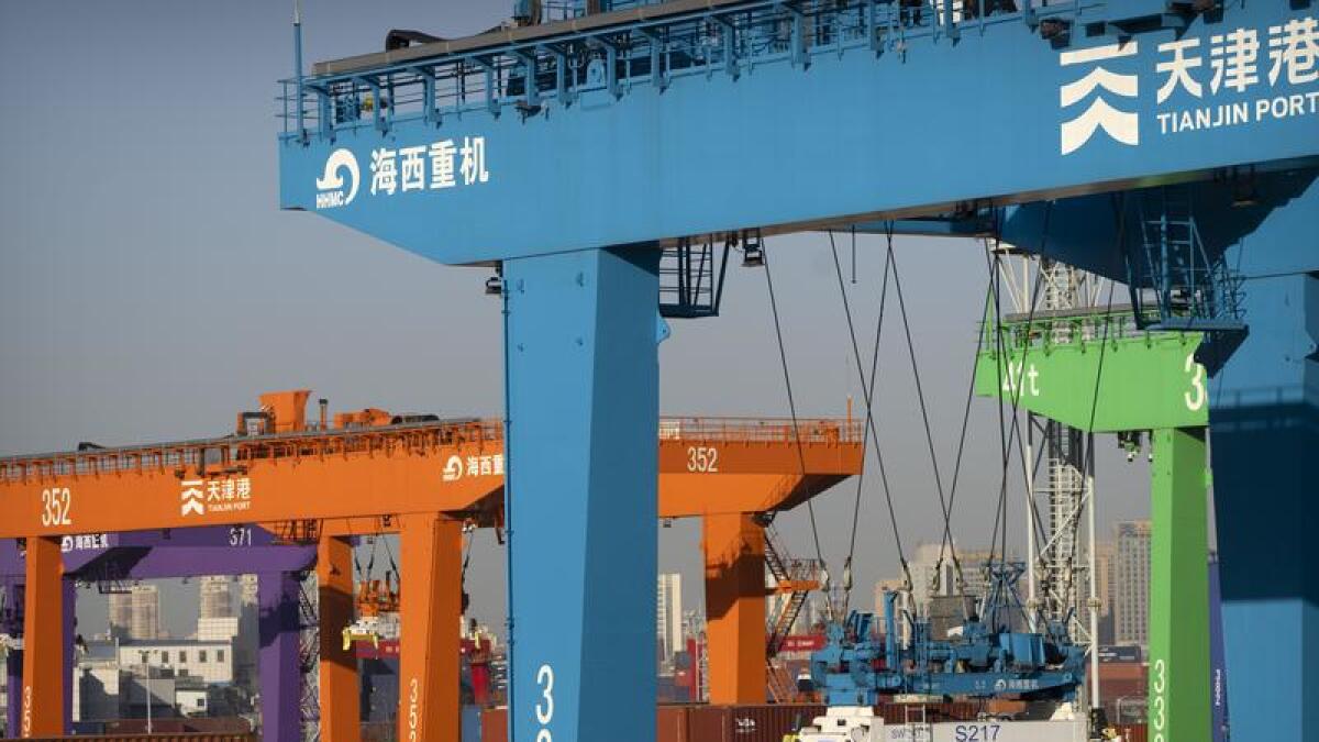 A crane lifts a shipping container in Tianjin, China