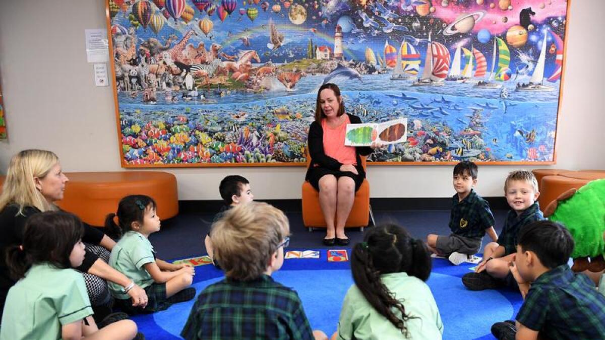 A teacher reads a story to young students in Brisbane