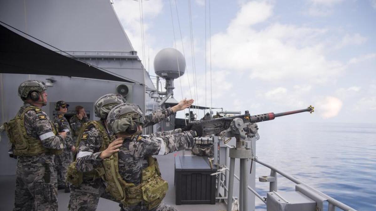 Sailors defend a ship during war games