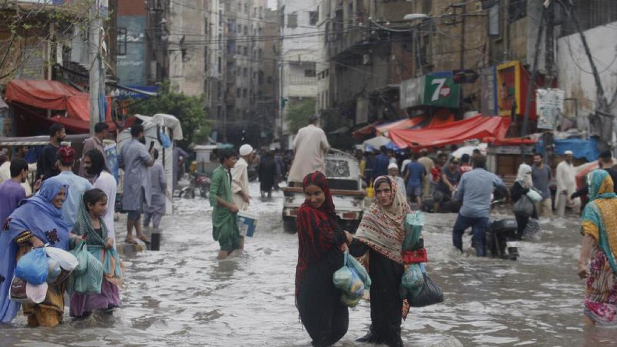 People wade through a flooded street in Karachi, Pakistan.