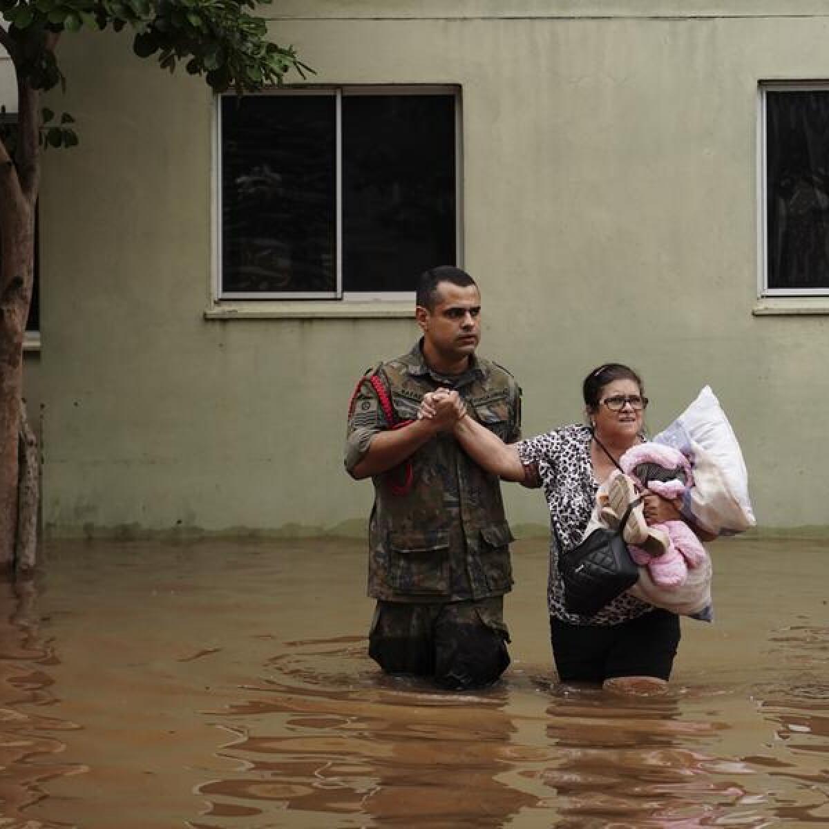 Soldier helps woman evacuate flooding in Canoas
