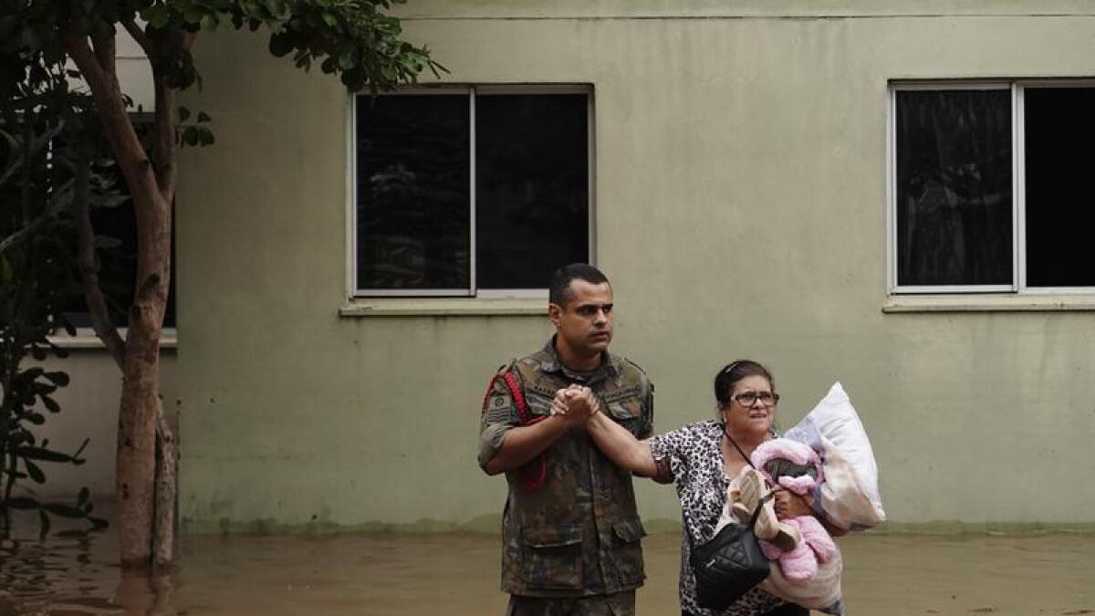 Soldier helps woman evacuate flooding in Canoas
