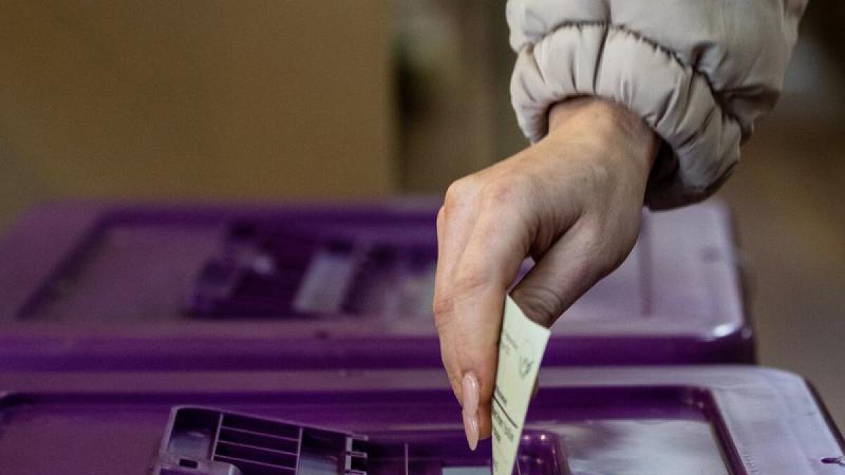 A woman putting her vote in the ballot box
