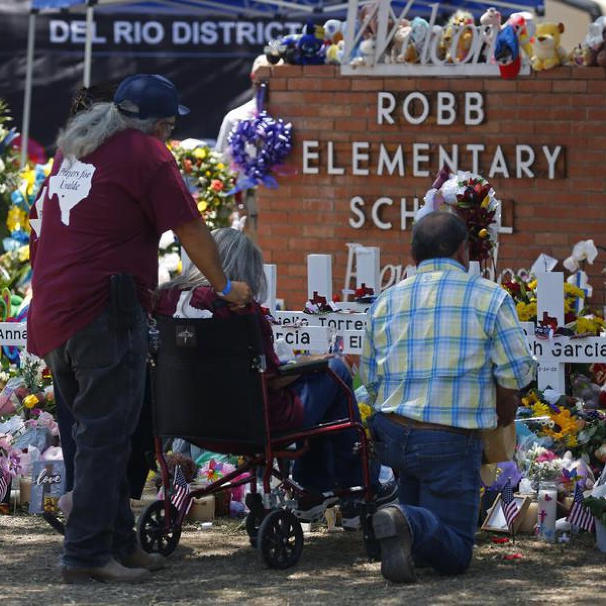 People pay their respects at a memorial outside the school