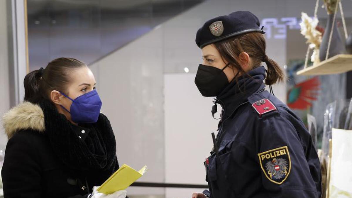 A police officer checks the vaccination status of a woman in Vienna