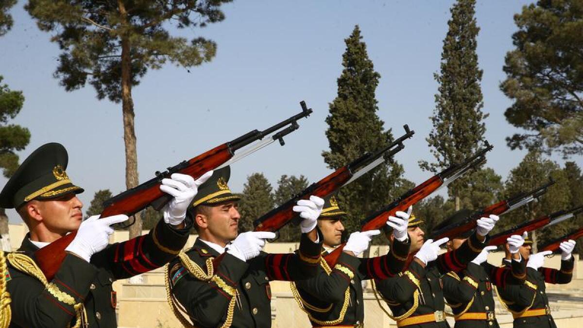 An Azerbaijan honour guard salute during a mass funeral.