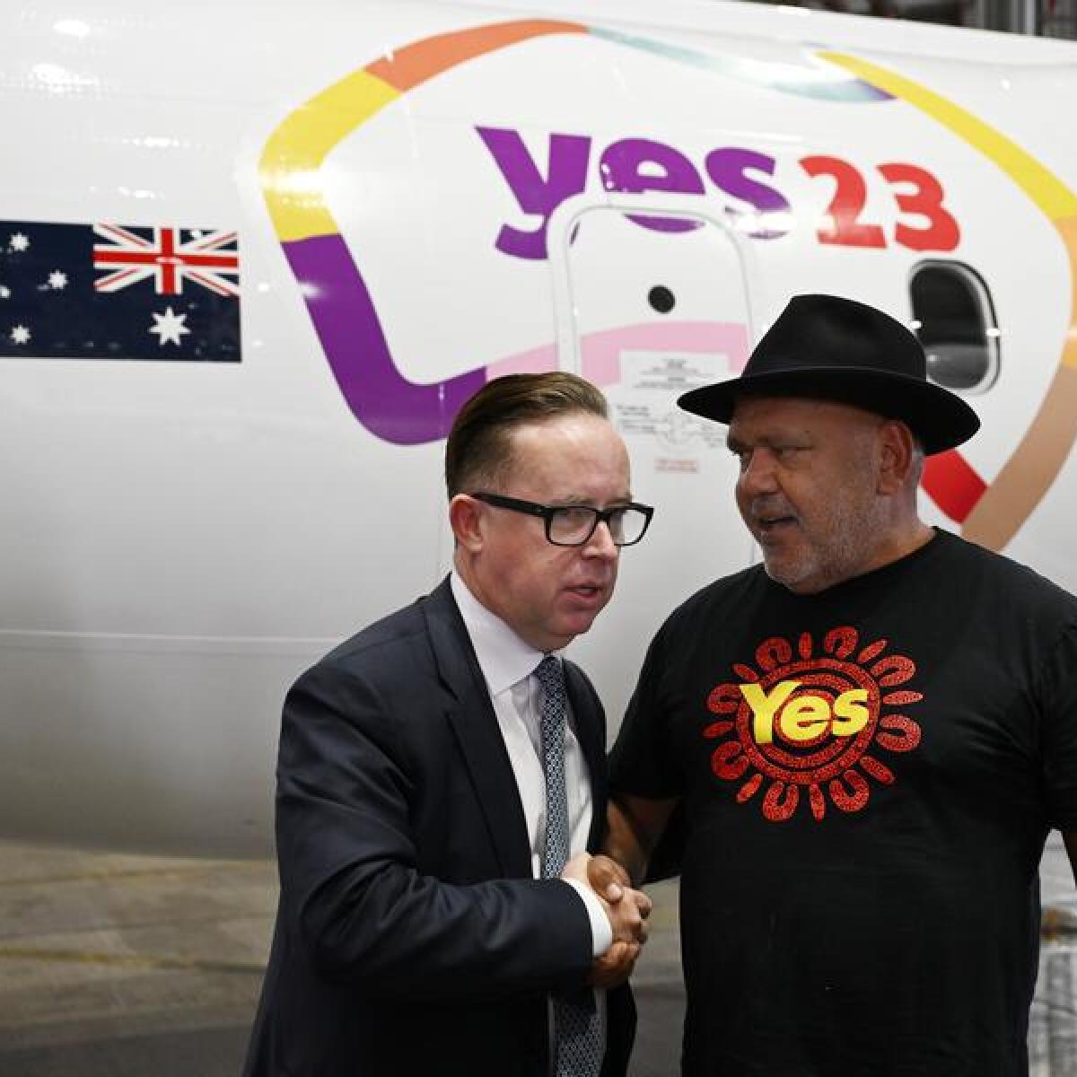 Alan Joyce and Noel Pearson in front of a plane painted with Yes 23.