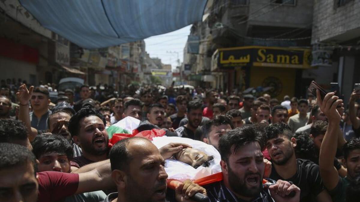 Mourners carry one body of a Palestinians killed in Gaza