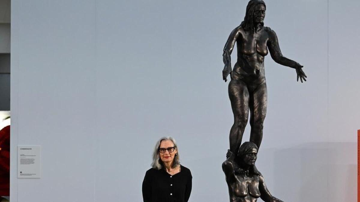 Artist Julie Rrap with her bronze sculpture
