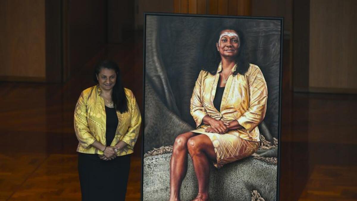 Nova Peris poses next to her portrait at Parliament House in 2019.