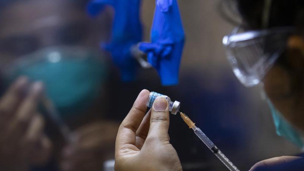 A health care worker prepares a Pfizer vaccine (file image)