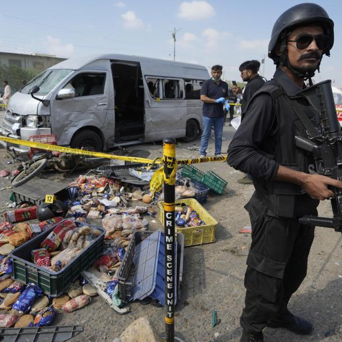 A police officer stands guard at site of a suicide attack in Karachi