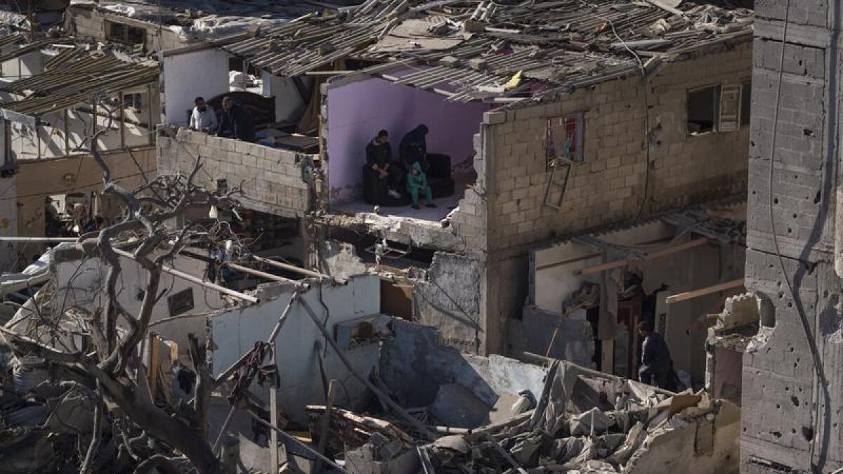 Palestinians look at the destruction after an Israeli strike