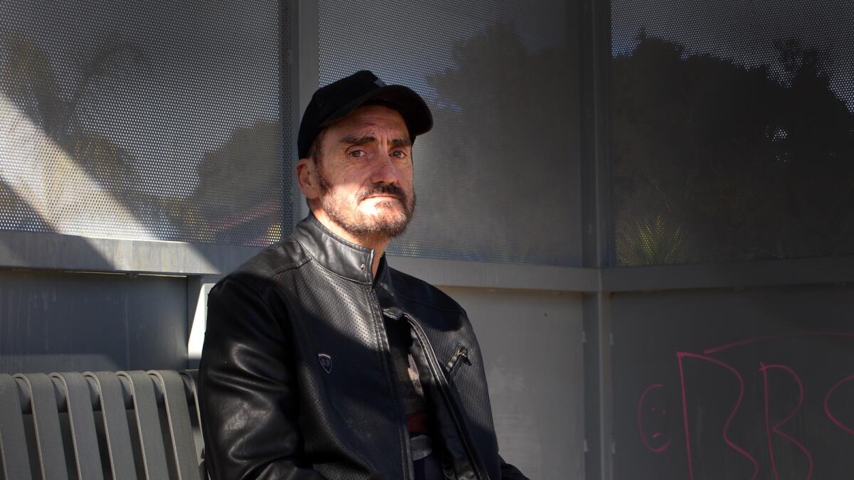 Dion Grahame in a leather jacket as a bus shelter in Shepparton. 
