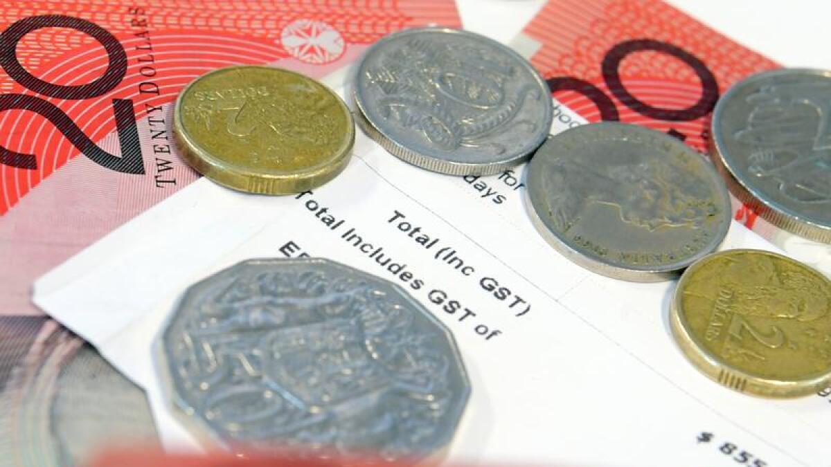 A receipt showing GST is shown alongside Australian notes and coins