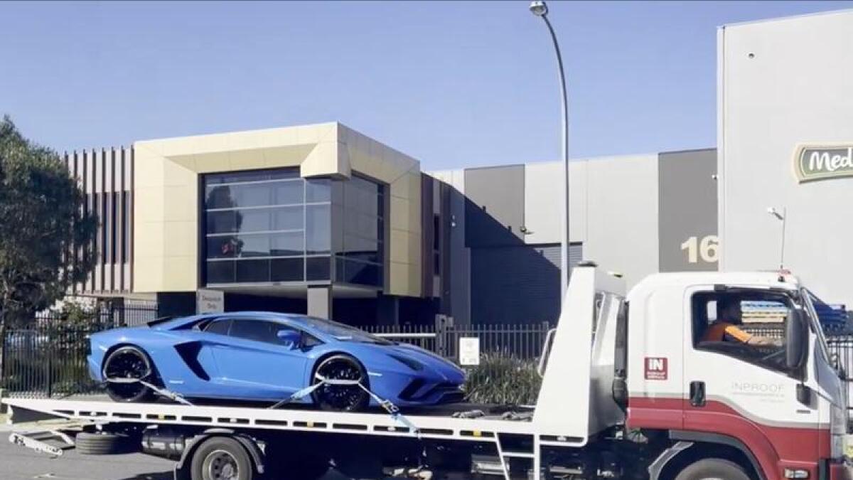 A Lamborghini on the back of a tow truck.
