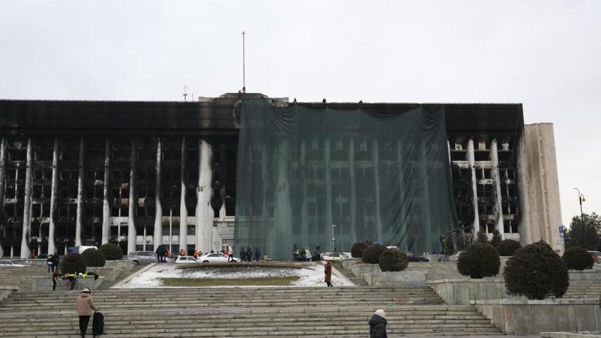 Municipal workers cover the burned city hall for repairs in Almaty