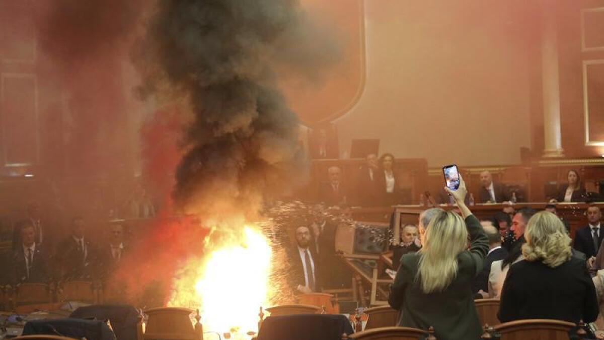 MPs throw a flare during a parliament session in Tirana, Albania