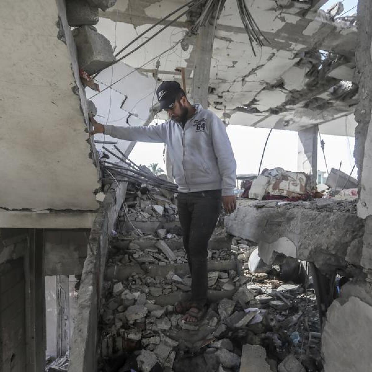 A Palestinian man stands in the ruins of a home in southern Gaza.