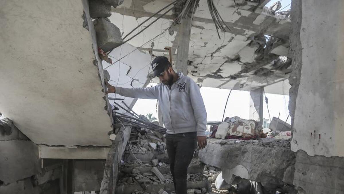 A Palestinian man stands in the ruins of a home in southern Gaza.