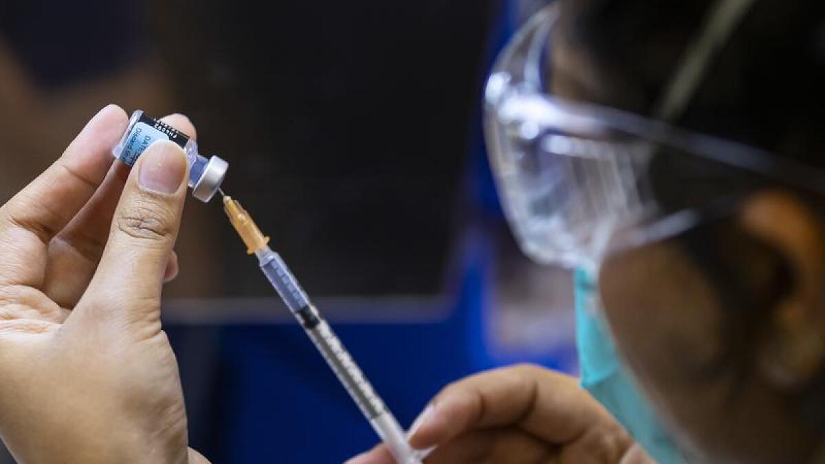 A file photo of a health worker prepping a vaccine