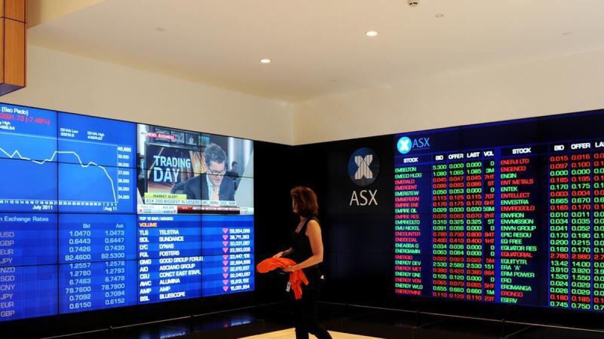 A woman looks at ASX trading displays.