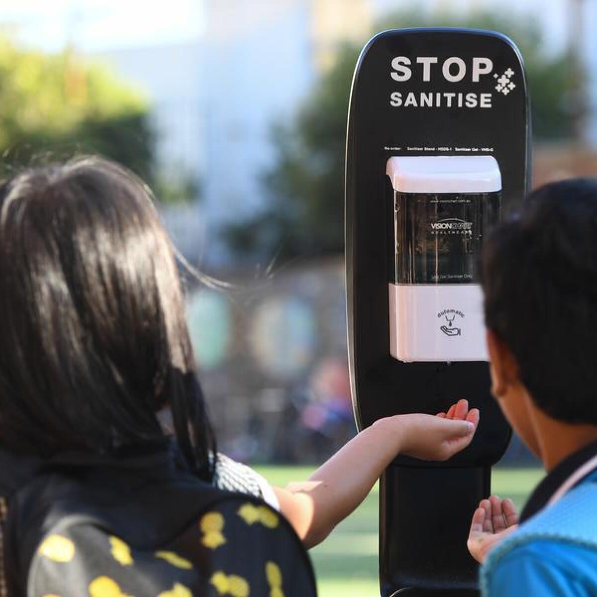 Students use a hand sanitiser station.