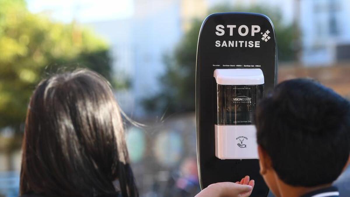 Students use a hand sanitiser station.