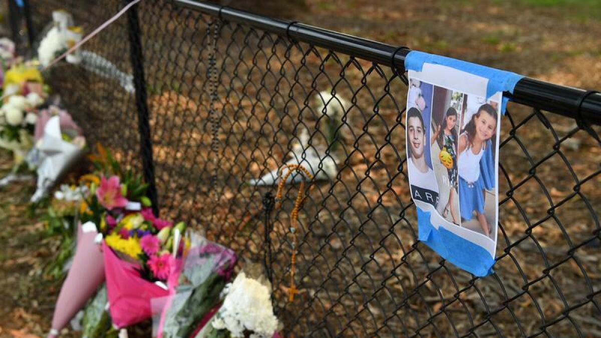 Flowers and photos of three of the children at crash site (file image)