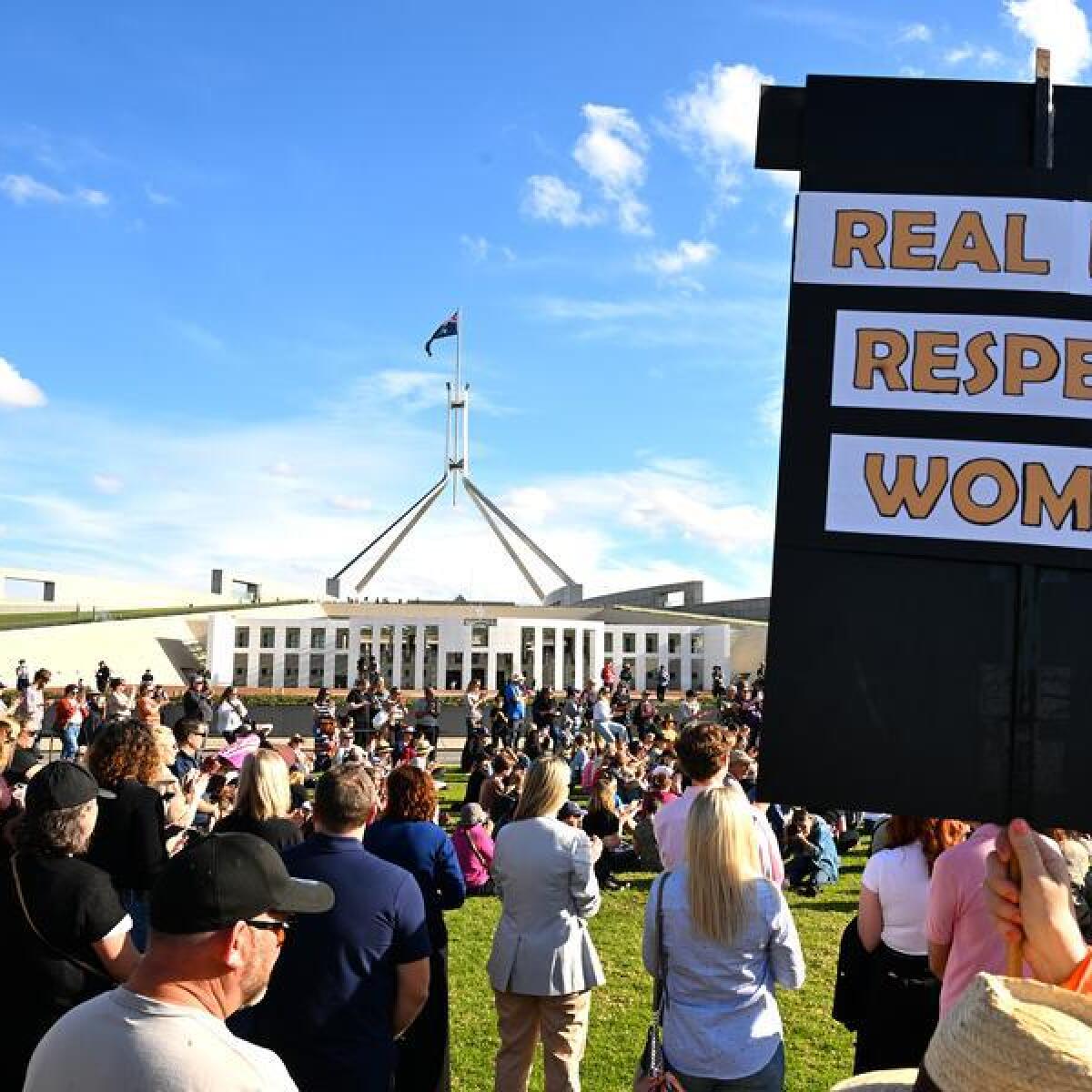 An anti-domestic violence protester holds a sign at a rally.