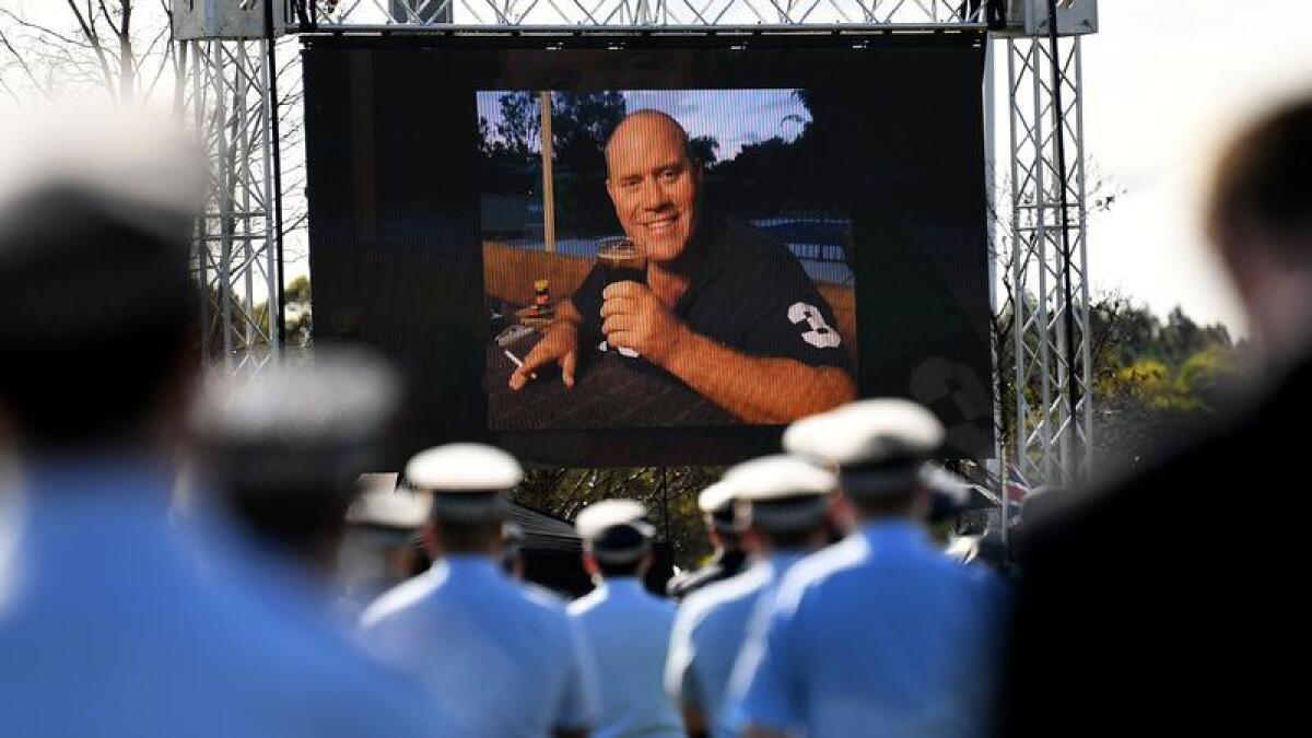 Officers watch a livestream of Senior Constable Dave Master's funeral 