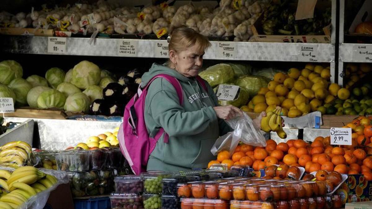 A woman selects fruits at a supermarket in London
