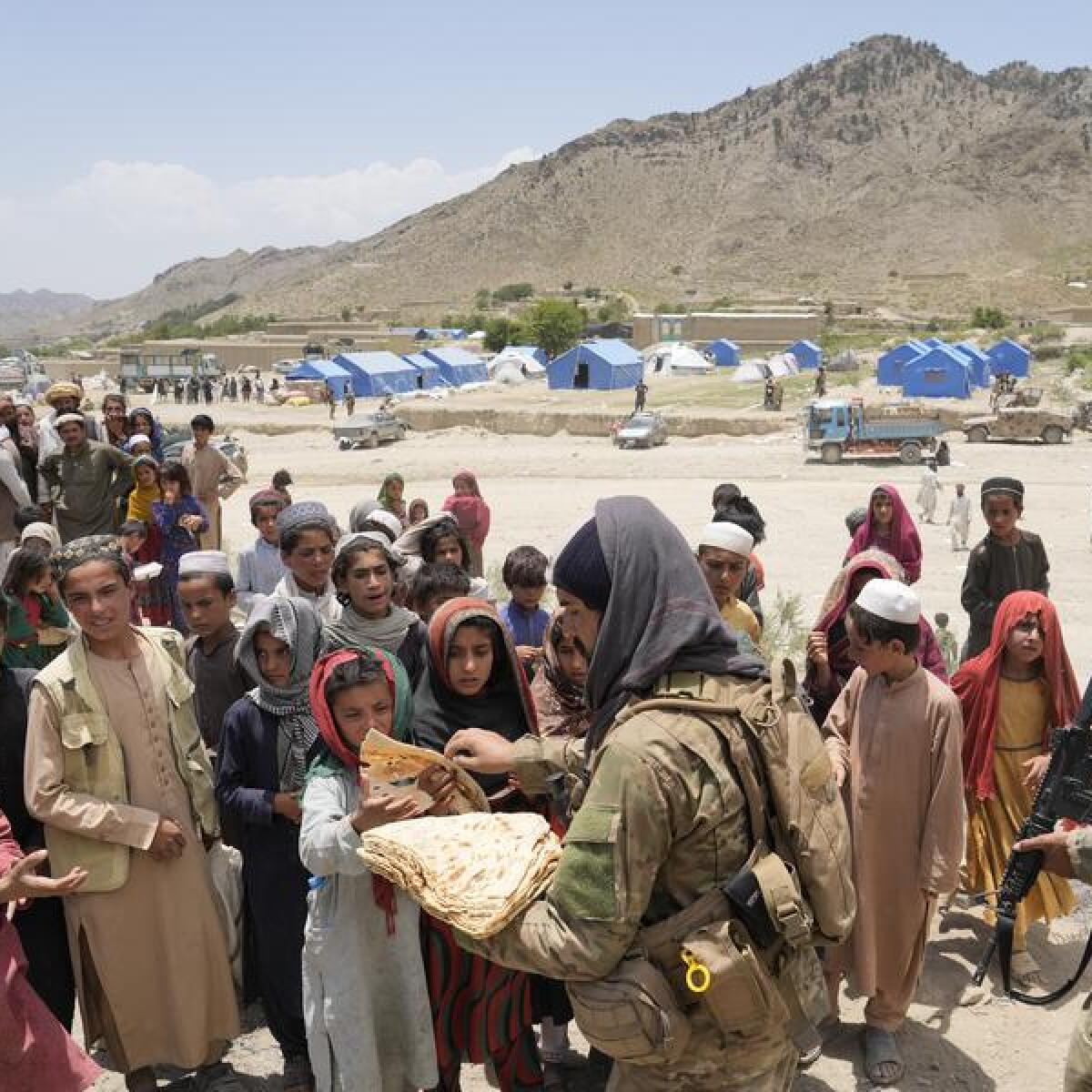Afghan quake survivors receive aid at a camp.