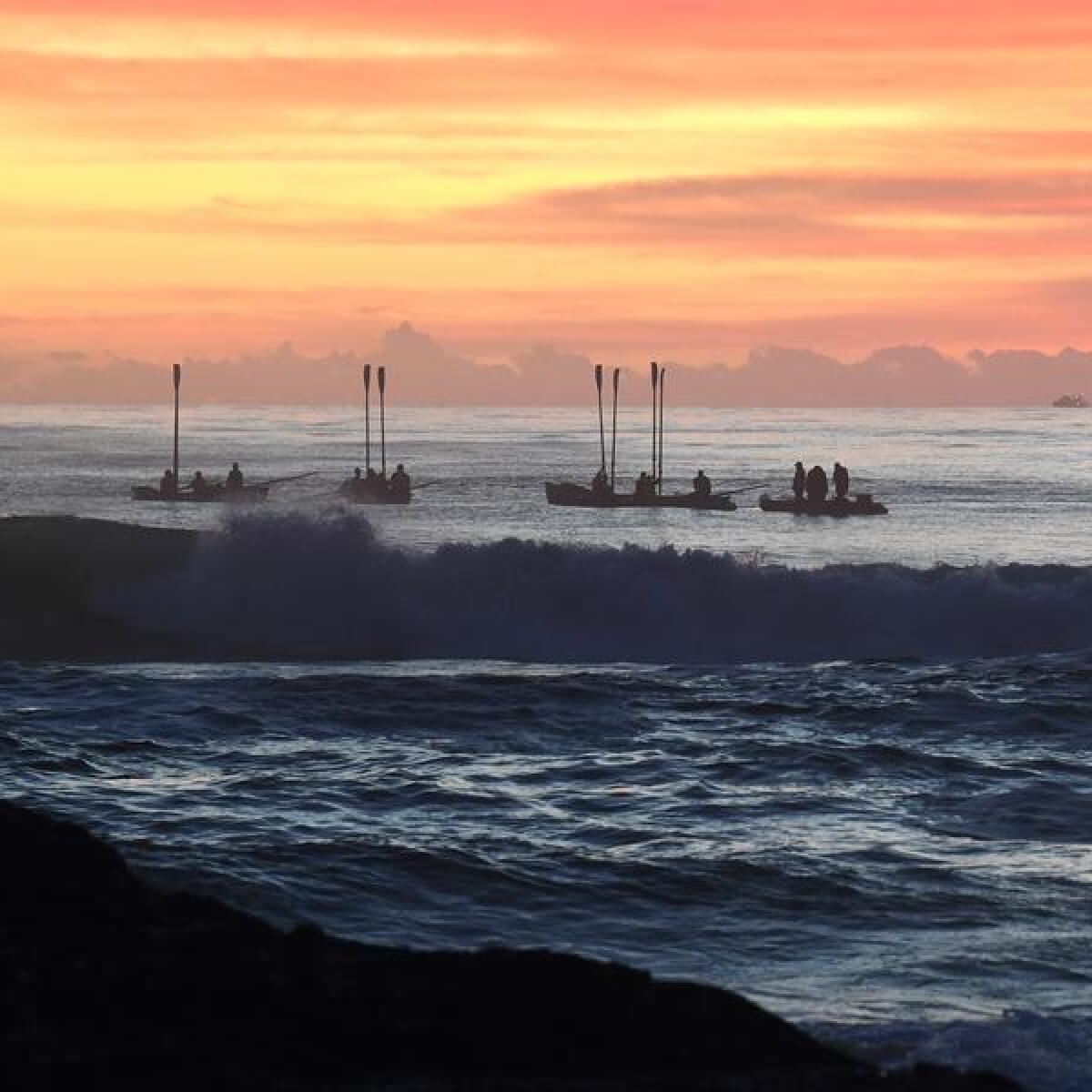 Surf boats perform a burial at sea during an Anzac Day Dawn Service
