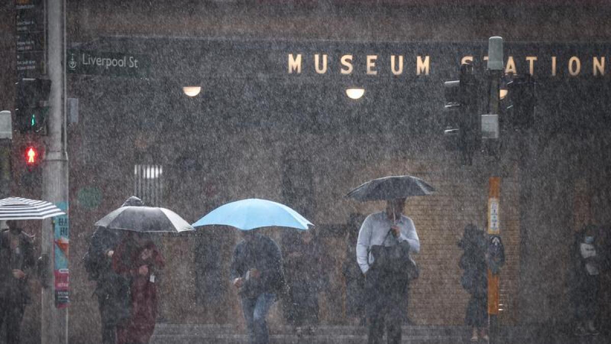 Pedestrians hold umbrellas during a downpour in Sydney.